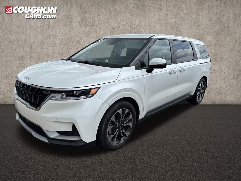 2024 Kia Carnival EX in Snow White Pearl — front three-quarter view